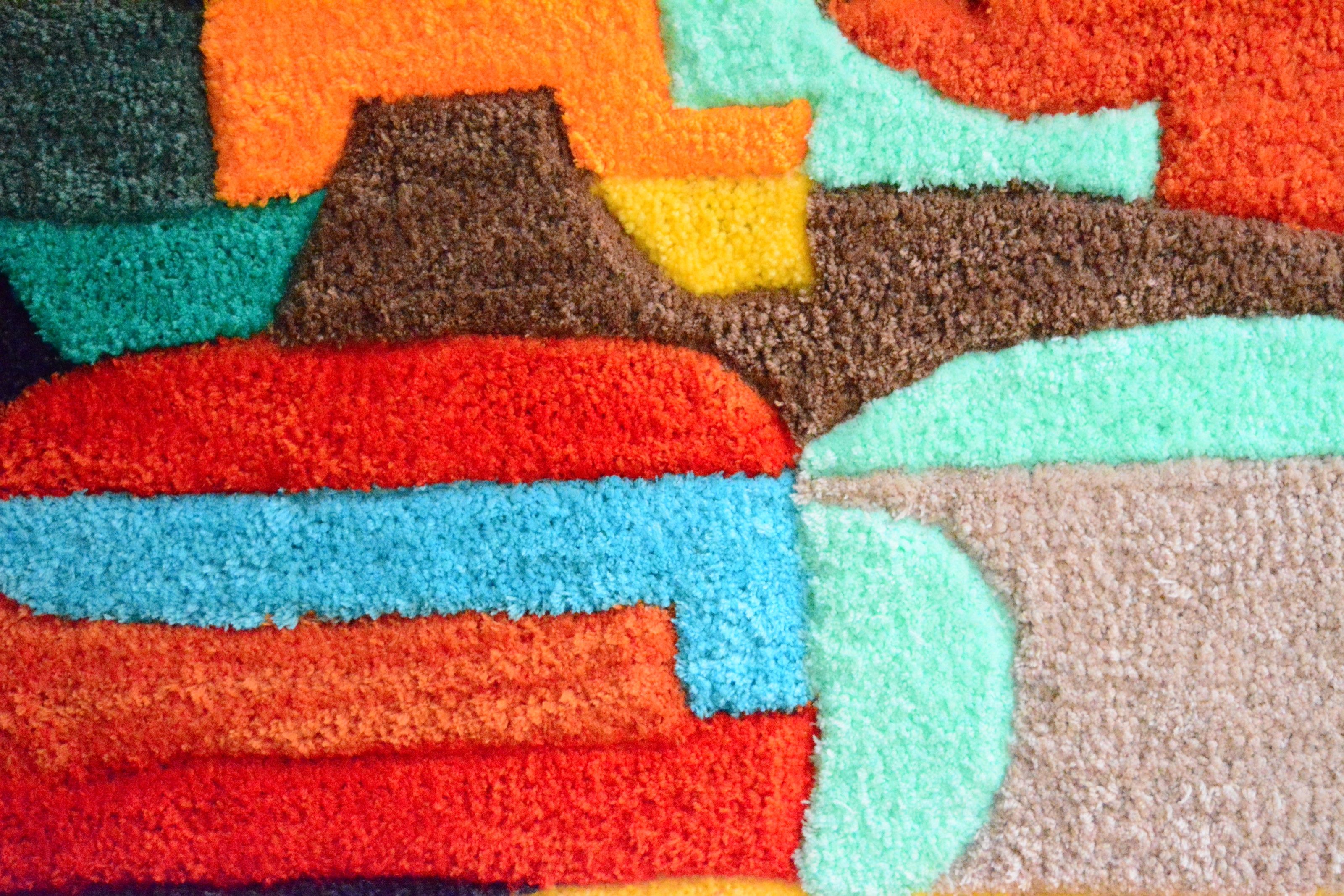 Alfombra tufting de formas orgánicas en colores vivos — rojo, verde, rosa y azul — creada en el taller Borrissol, Mataró, Barcelona